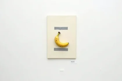 Banane scotchée sur un mur blanc dans une galerie d'art contemporain minimaliste, œuvre provocatrice de street art conceptuel