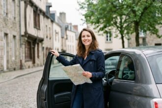 Jeune femme souriante devant une voiture en ville à Rennes