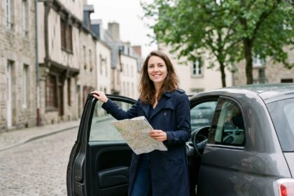 Jeune femme souriante devant une voiture en ville à Rennes